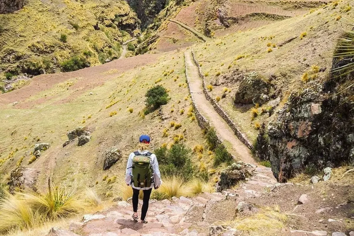Hiker walking beside a river in the Andes