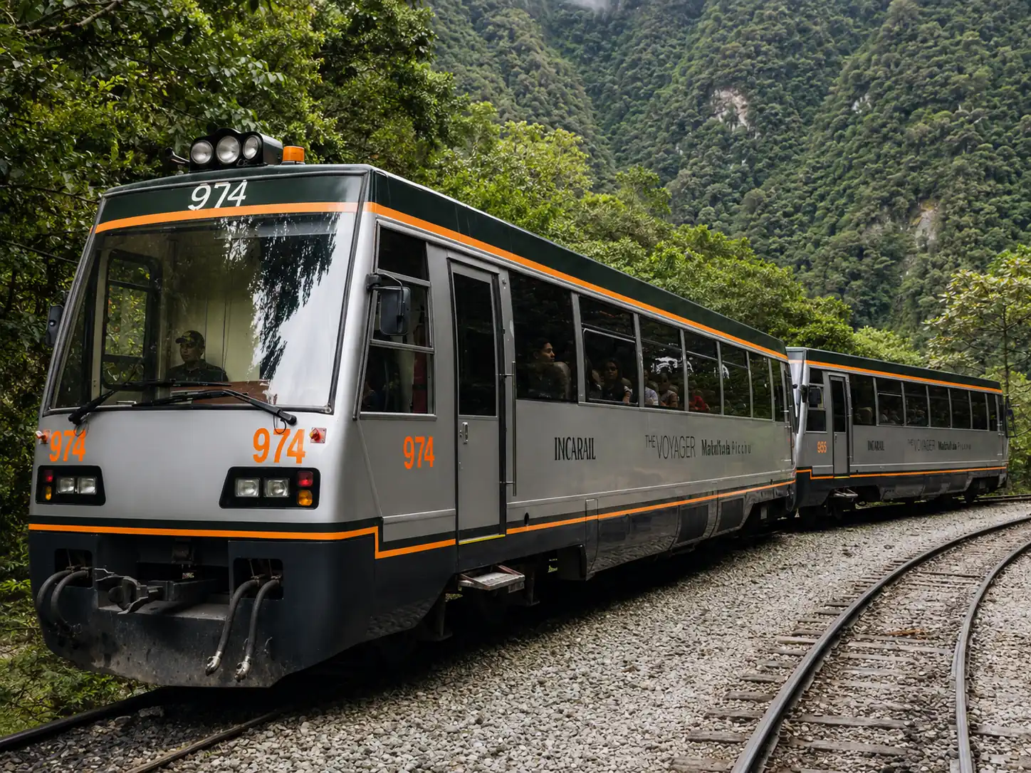 Inca Rail Voyager train traveling through the lush mountain landscape near Machu Picchu