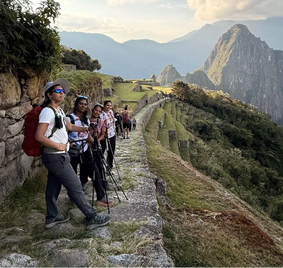 Travelers hiking along the Machu Picchu trail with mountain scenery and Inca terraces in Peru
