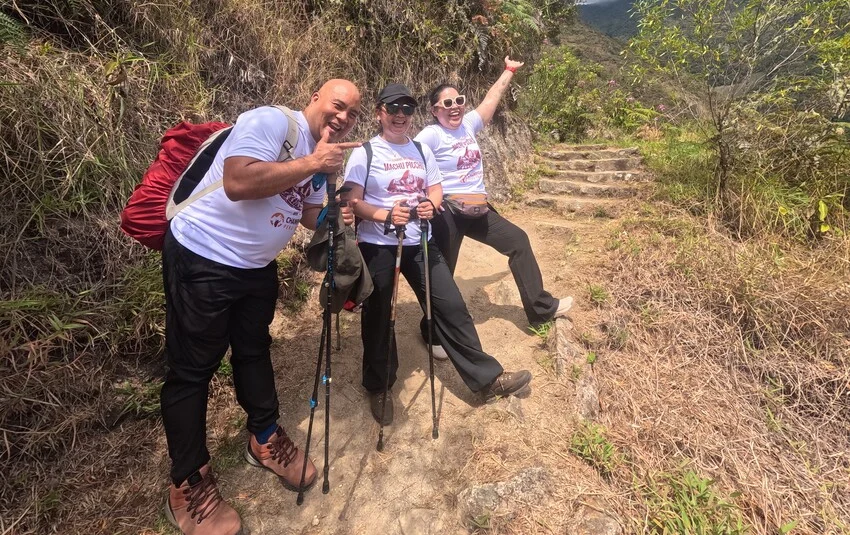 Three travelers hiking along a mountain path during a Champions Peru Travel trekking experience