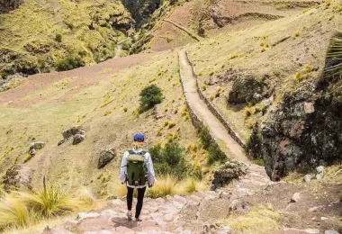 Hiker walking beside a river in the Andes