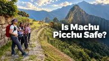 Group of tourists standing on a stone pathway overlooking the mountainous landscape surrounding Machu Picchu